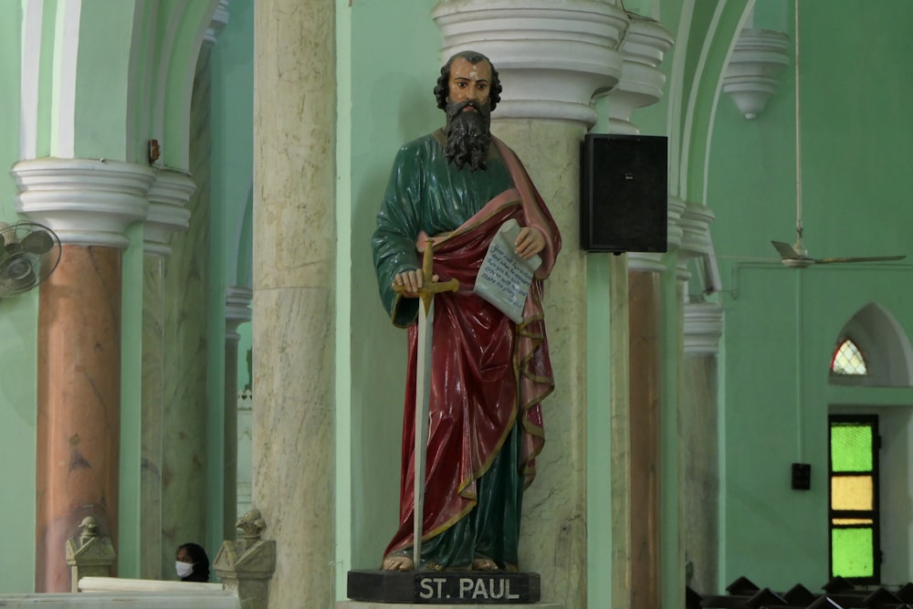 a statue of a man holding a book in a church