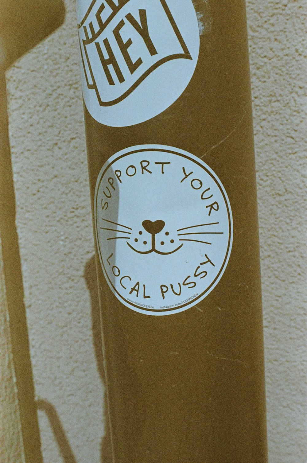 a sticker on the side of a brown pole