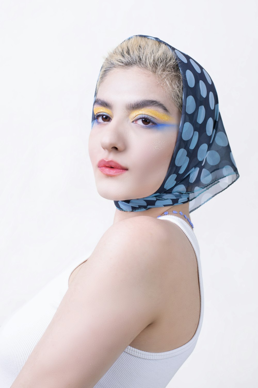 a woman with blue and white makeup and a veil on her head
