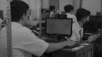 a man sitting in front of a computer on top of a desk