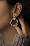 a close up of a person wearing a pair of earrings