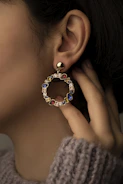 a close up of a person wearing a pair of earrings