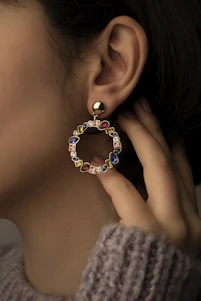 a close up of a person wearing a pair of earrings