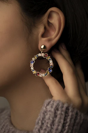 a close up of a person wearing a pair of earrings