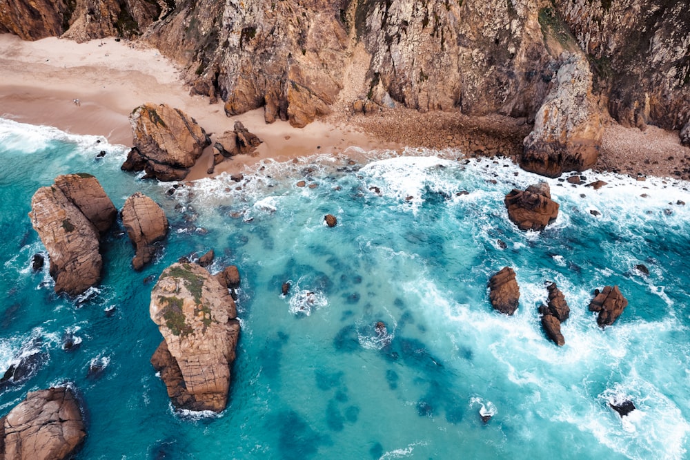 an aerial view of the ocean and rocky coastline