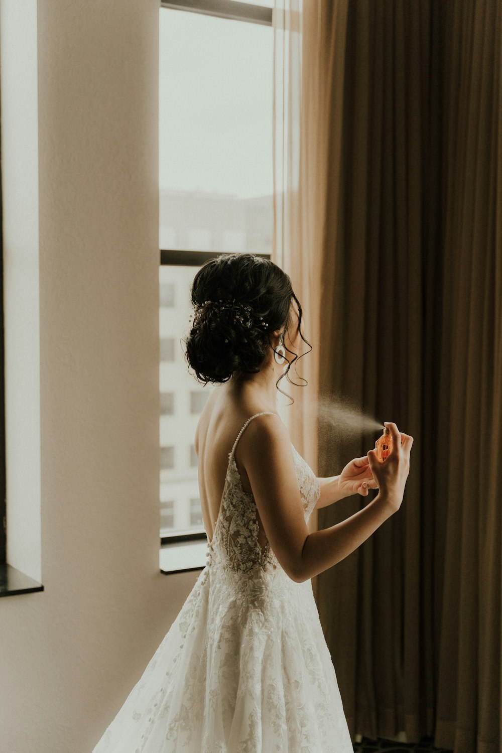 a woman in a wedding dress spraying herself with water