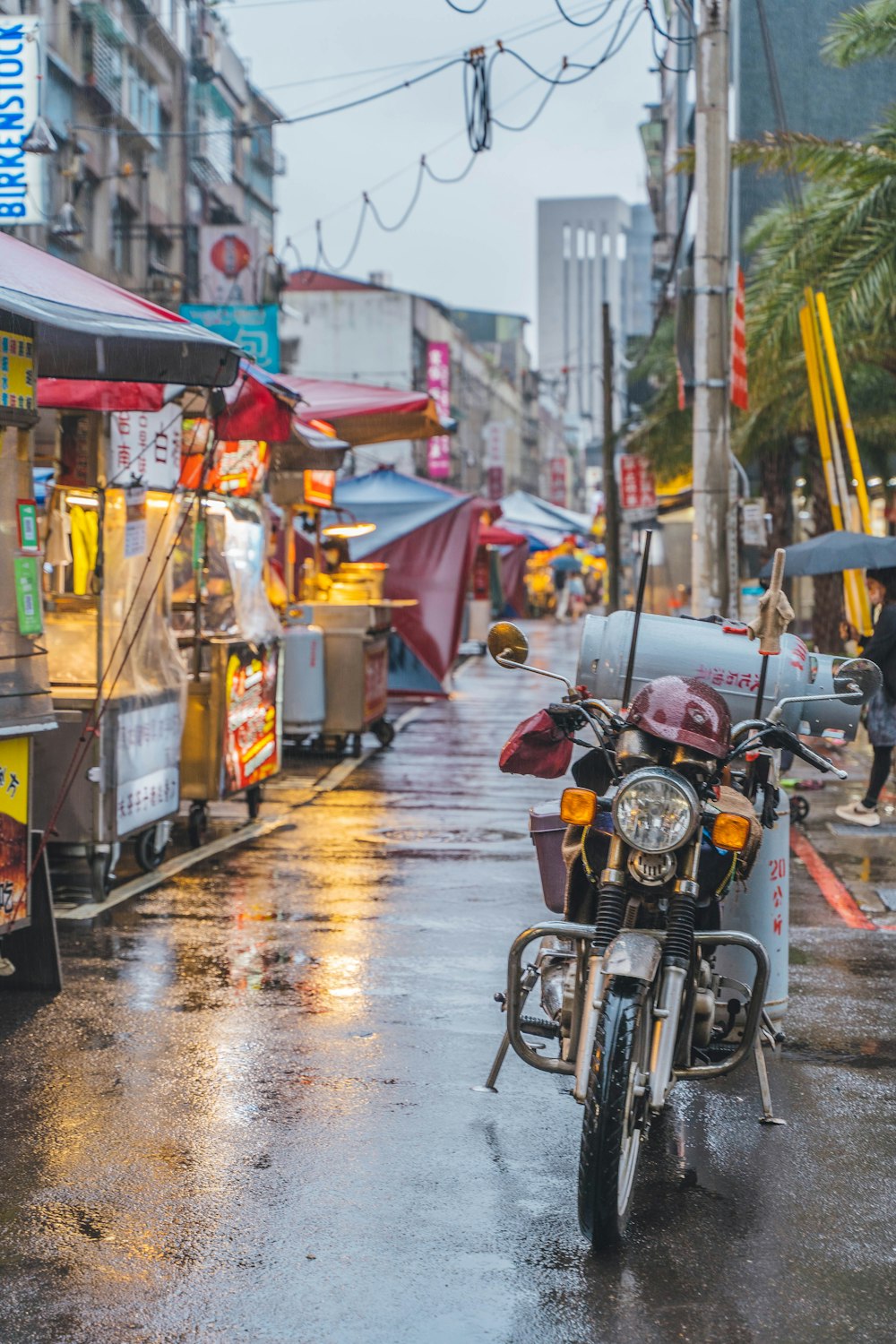 a motorcycle parked on the side of a wet street