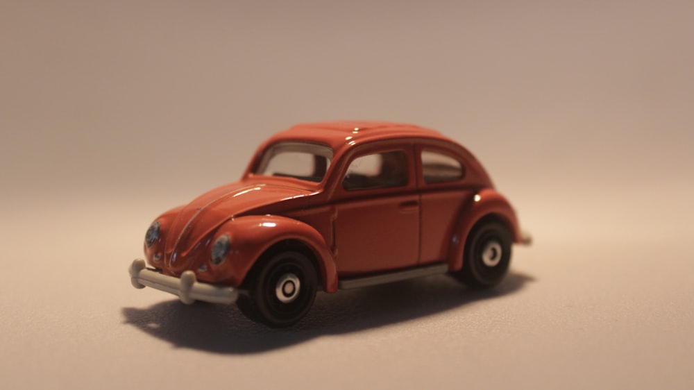 a red toy car sitting on top of a table