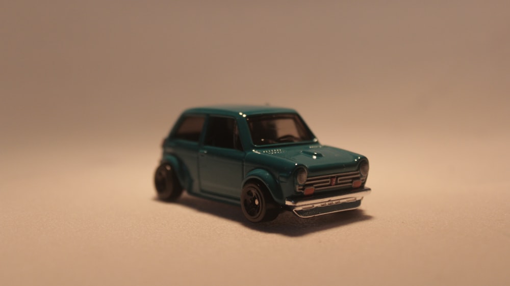 a toy car is sitting on a white surface