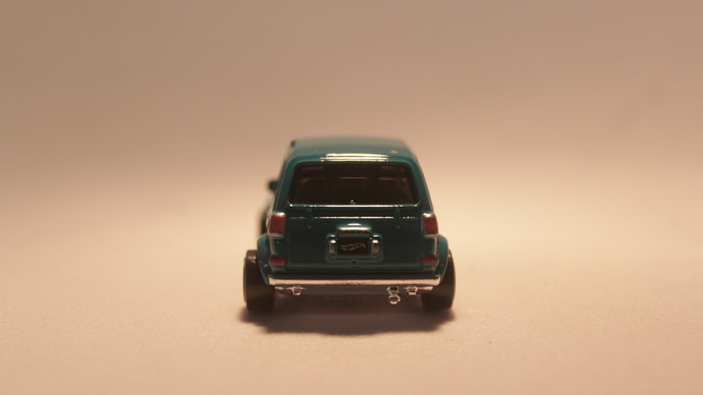 a toy car is sitting on a white surface