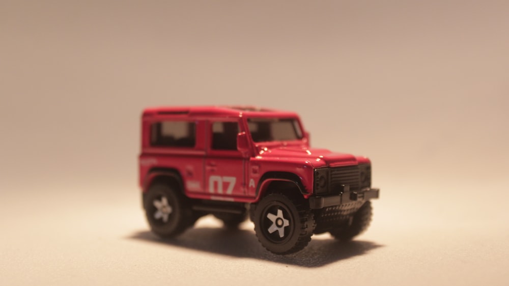 a red toy truck is on a white surface