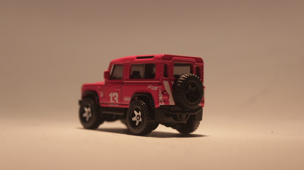 a red toy truck is on a white surface