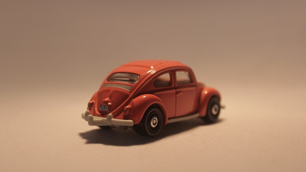 a red toy car sitting on top of a table