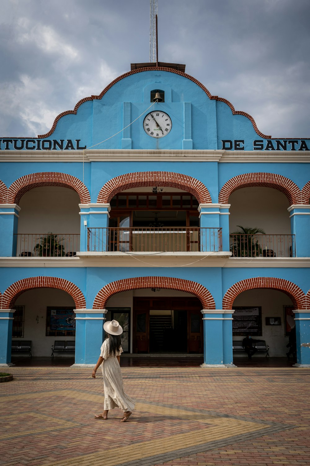 a woman walking in front of a blue building