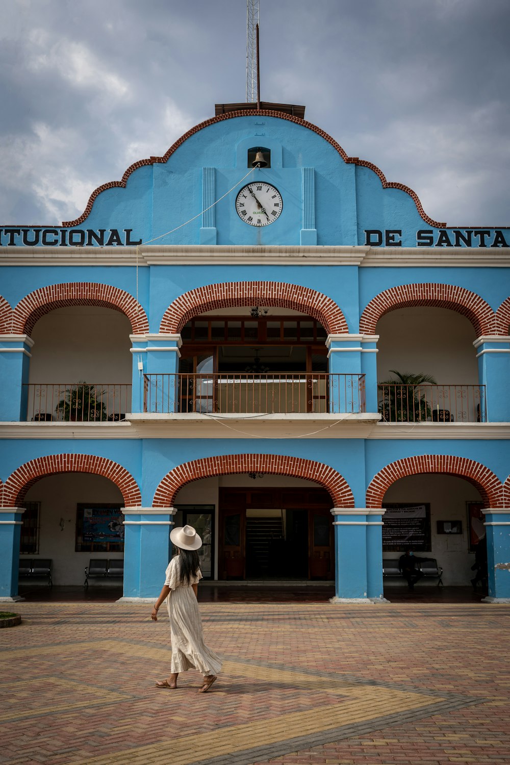 Une femme marchant devant un bâtiment bleu