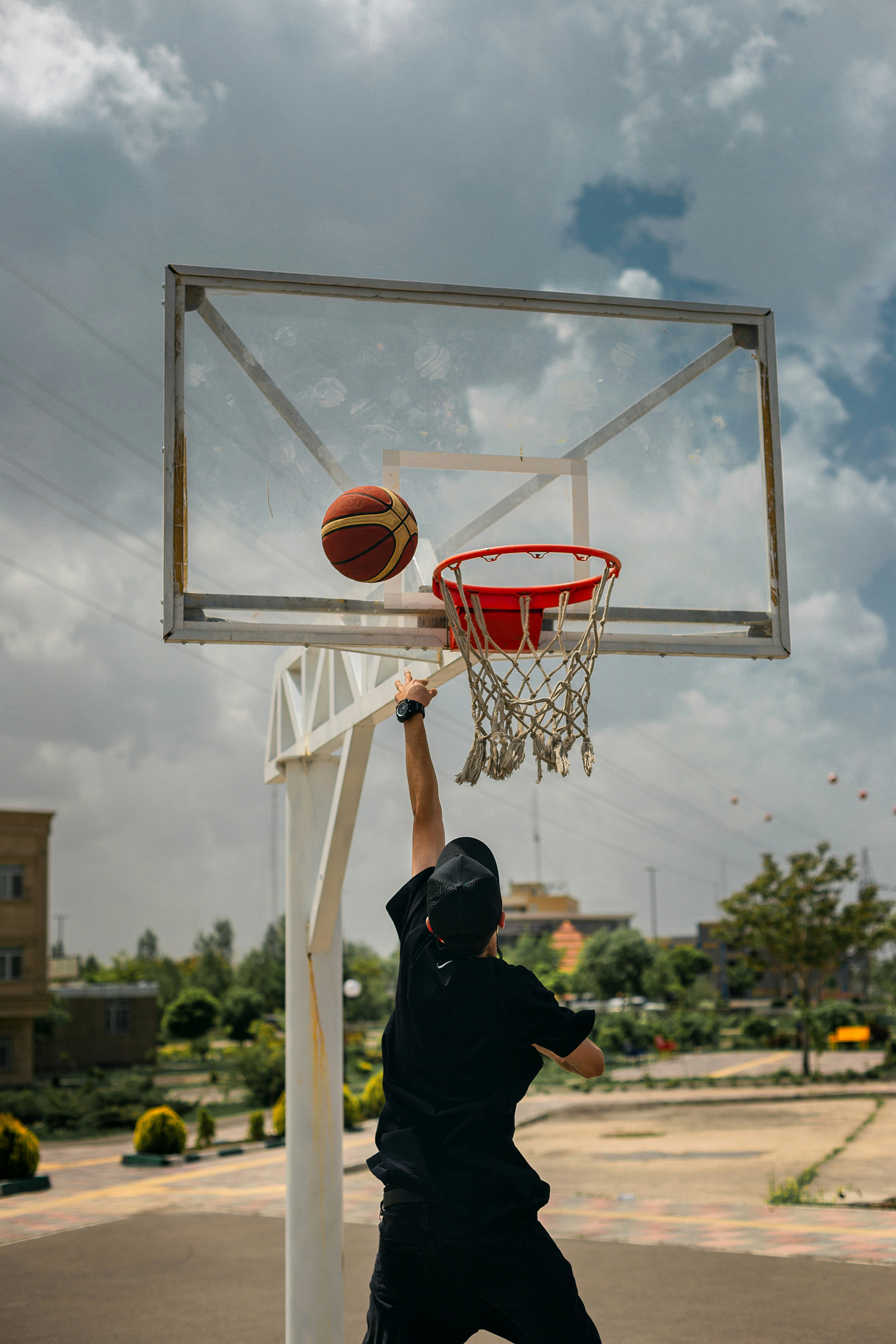 A man dunking a basketball into a basketball hoop photo Free