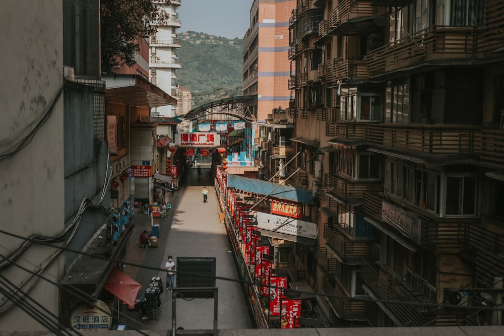 a narrow city street with buildings and signs