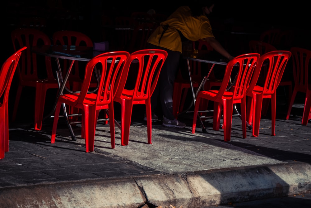 uma fileira de cadeiras vermelhas sentadas uma ao lado da outra