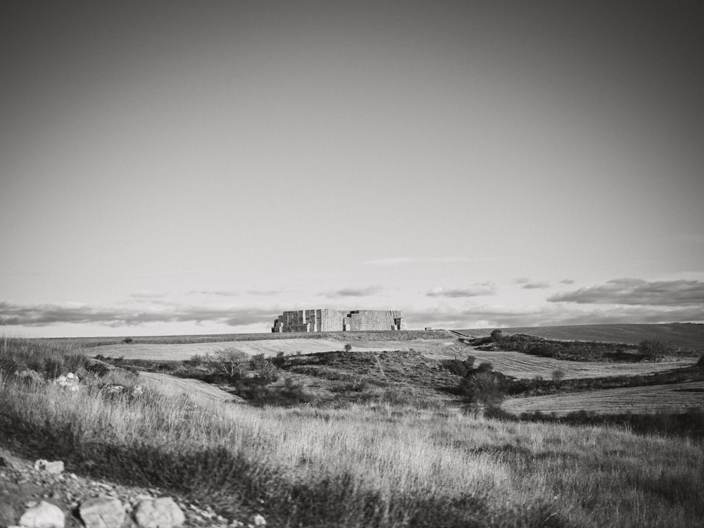 a black and white photo of a house in a field