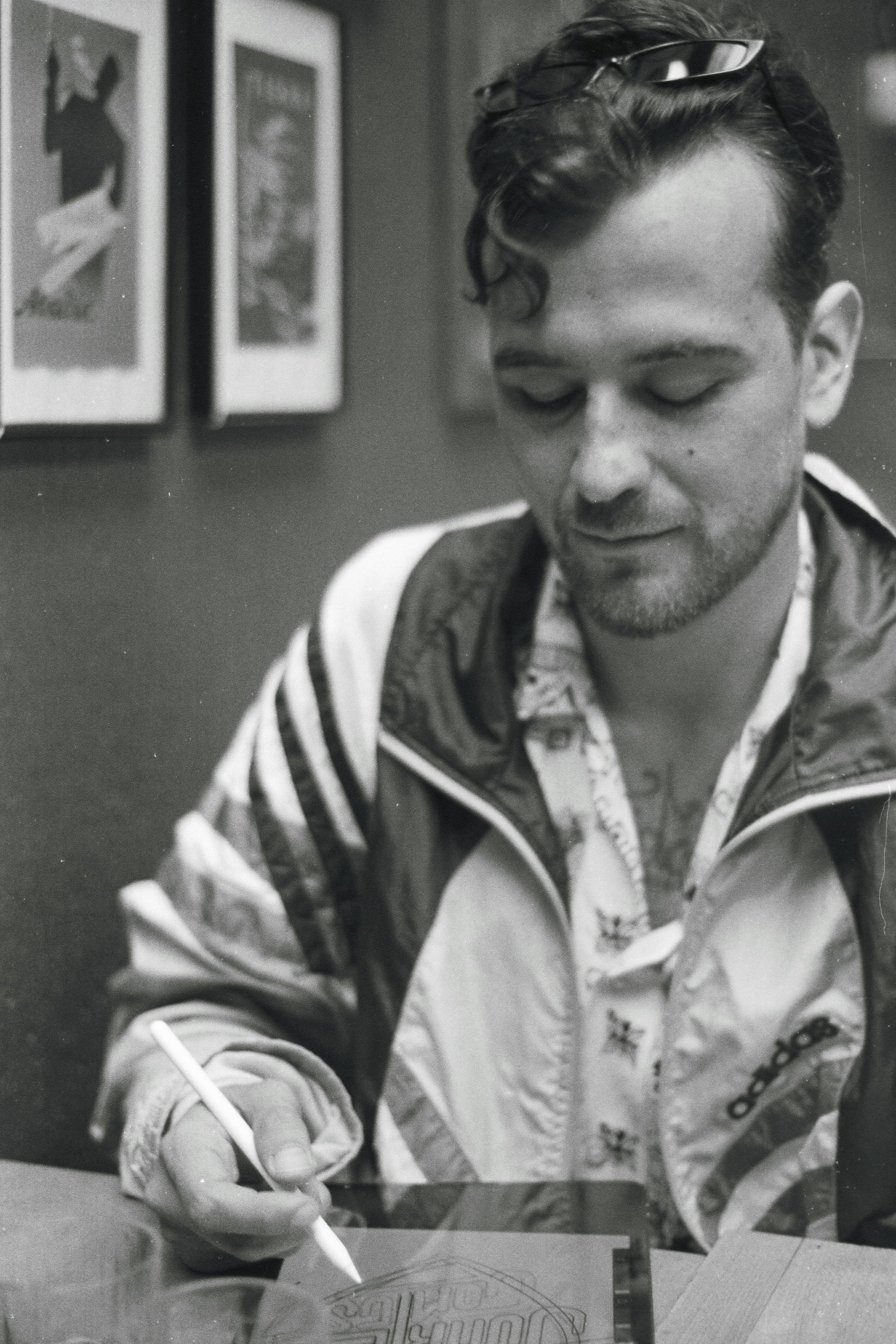 a man sitting at a table writing on a piece of paper