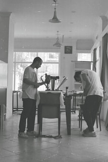 a couple of men standing next to a table