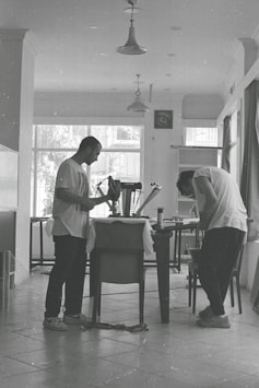 a couple of men standing next to a table