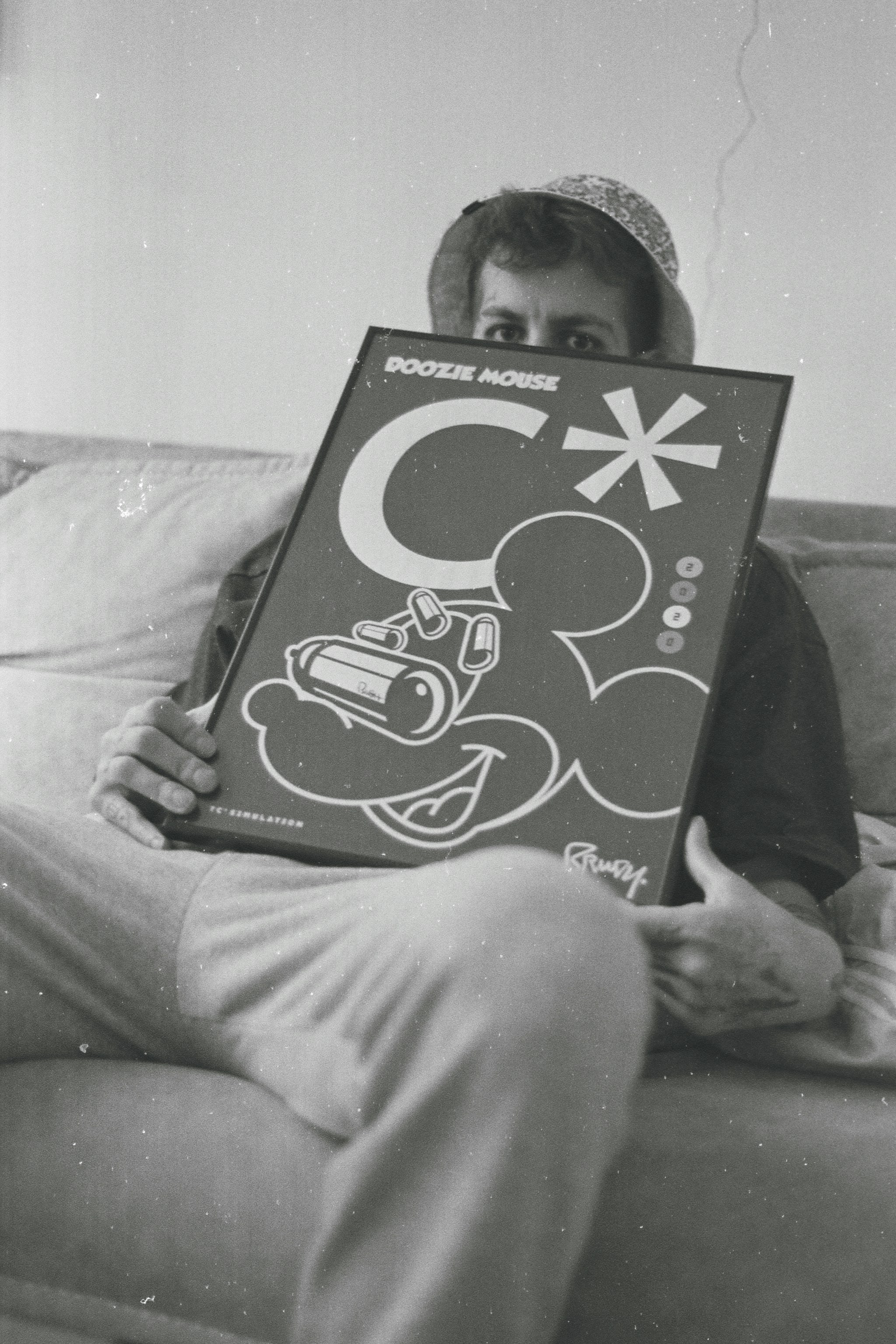a man sitting on top of a couch holding a sign