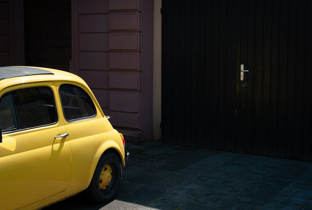 a small yellow car parked in front of a building