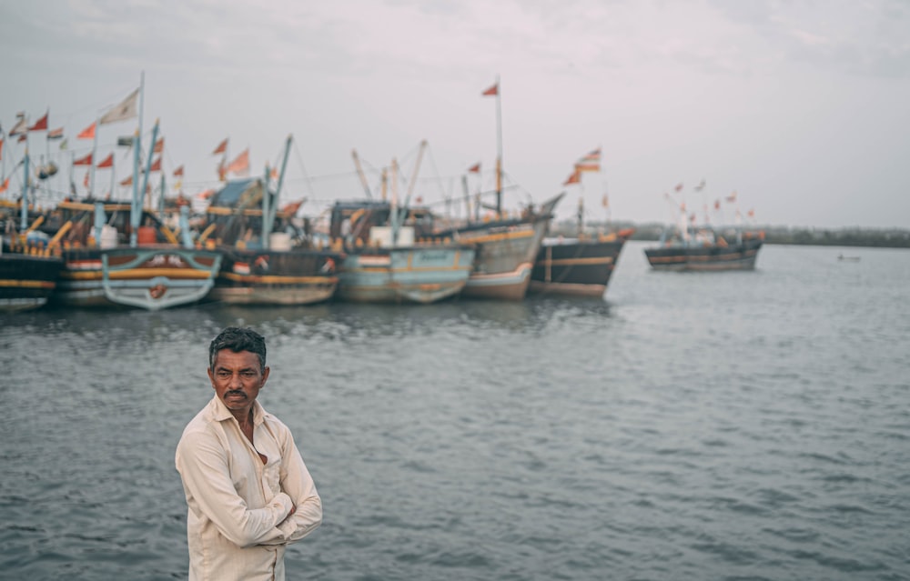a man standing in front of a bunch of boats