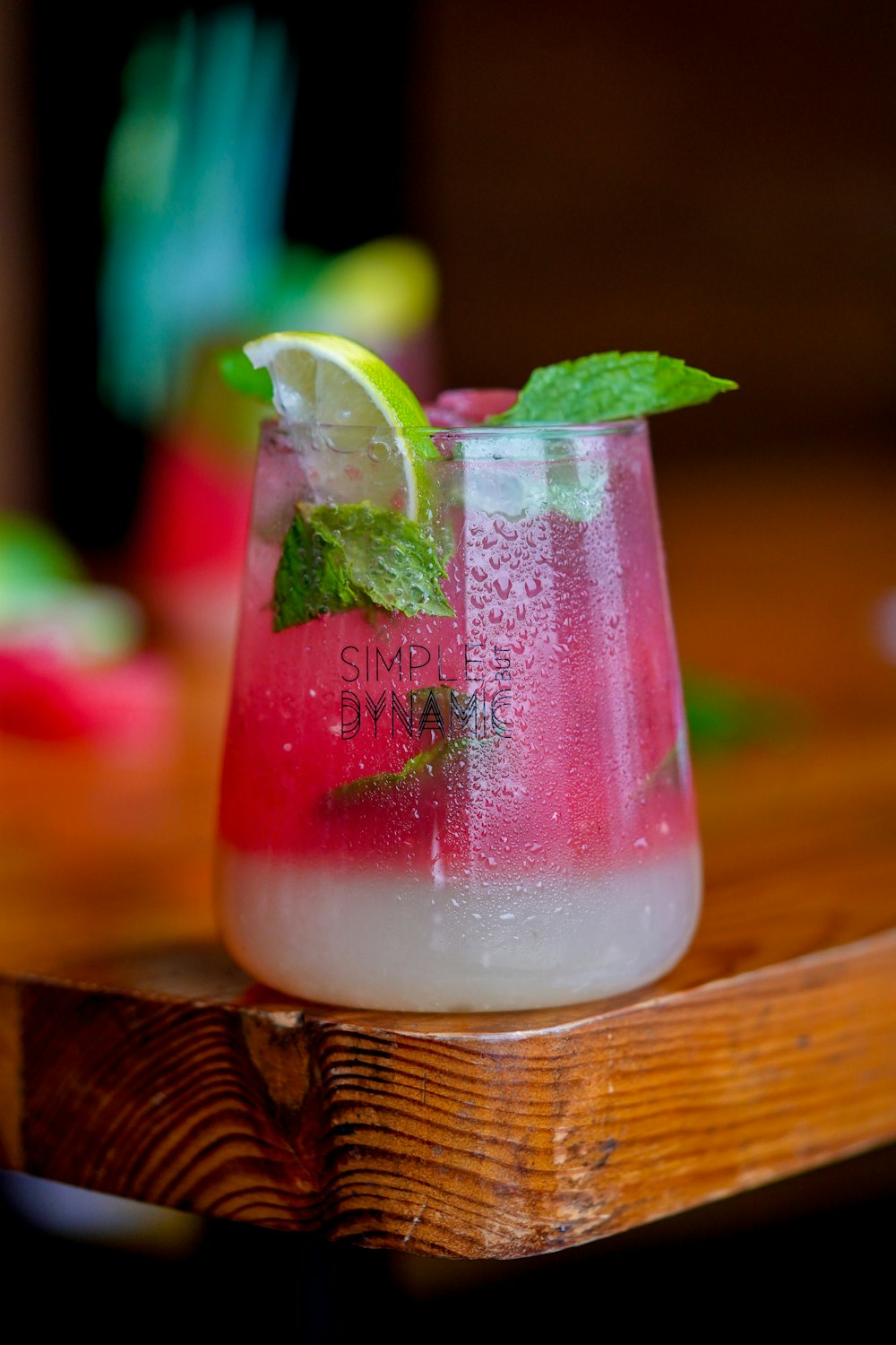 a glass filled with a drink sitting on top of a wooden table