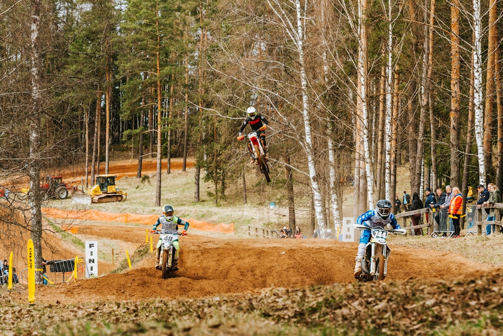 Un grupo de personas montando motos de cross en una pista de tierra