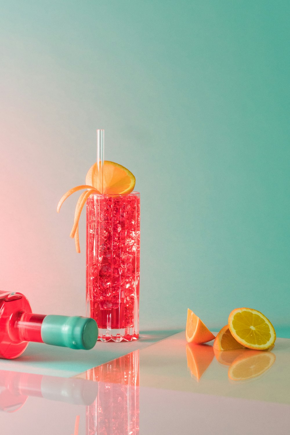 a bottle of liquid with a straw and a slice of orange