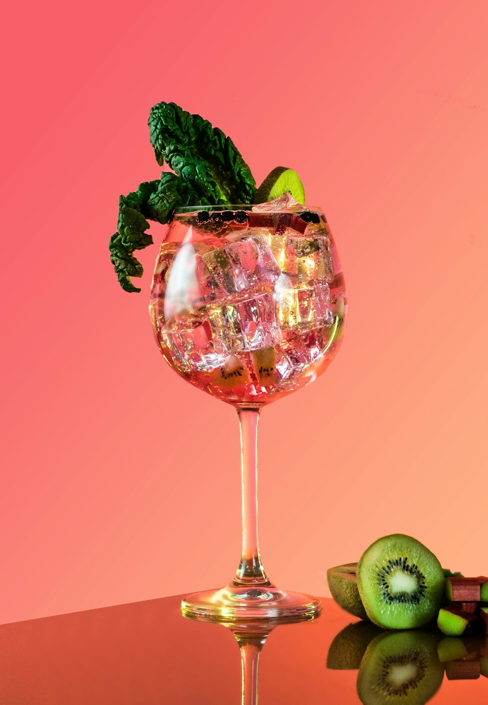 a glass filled with ice and a kiwi on top of a table