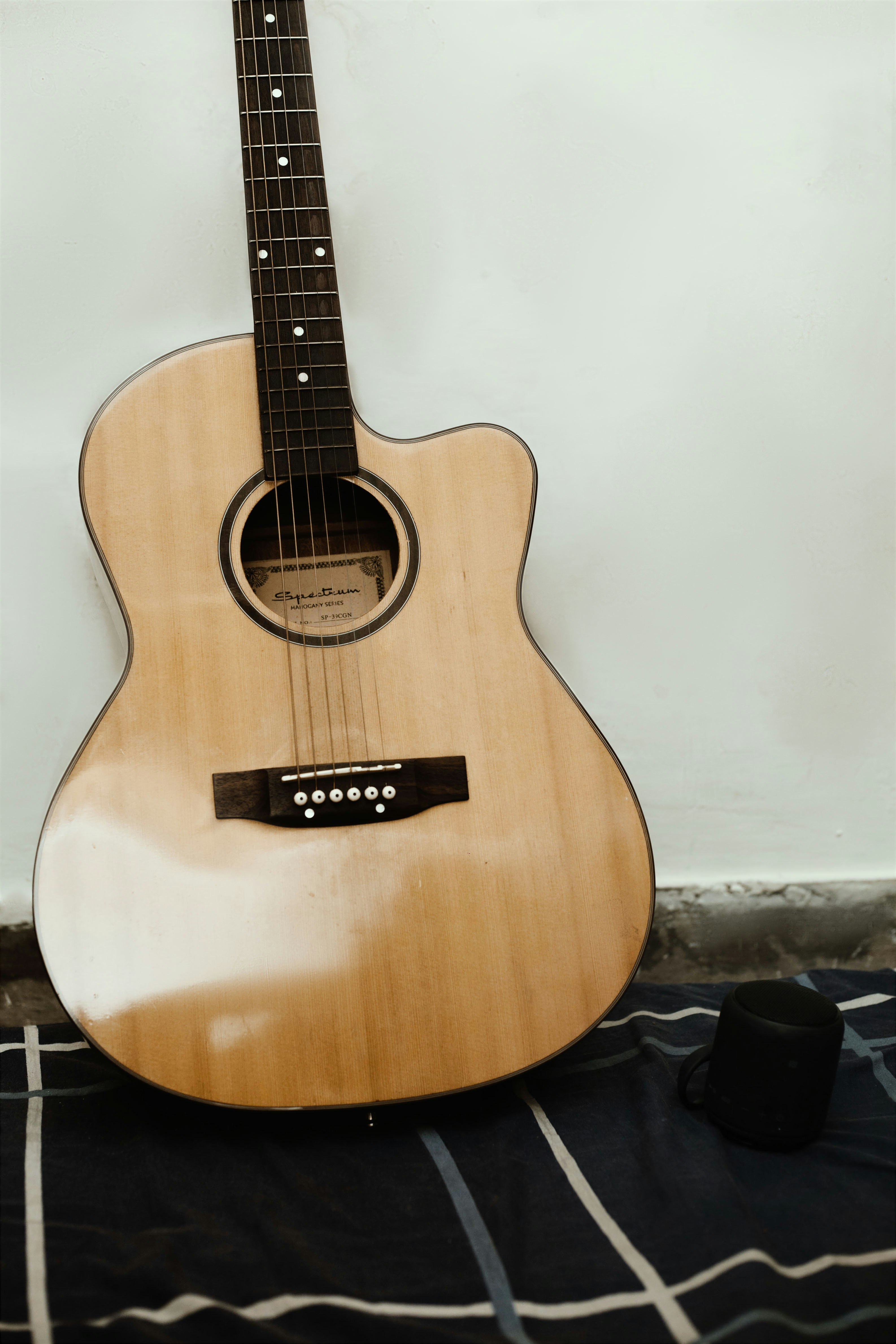 Eine Gitarre sitzt auf einem Bett neben einer Wand