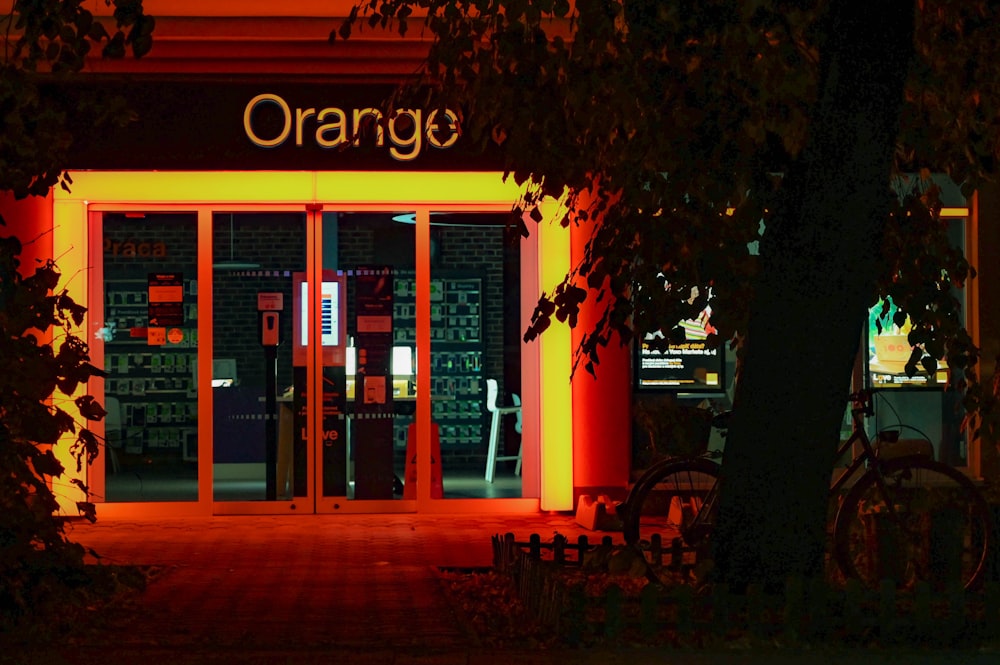 une entrée éclairée en orange dans un bâtiment la nuit