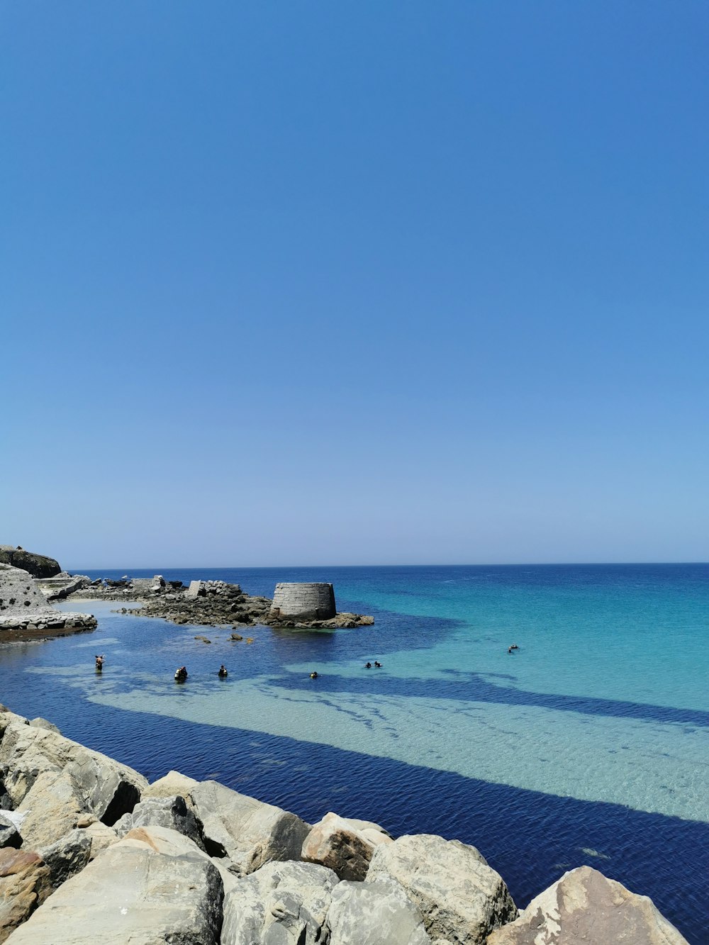 a body of water sitting next to a rocky shore