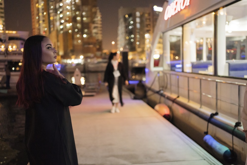 a woman standing on a sidewalk in front of a building