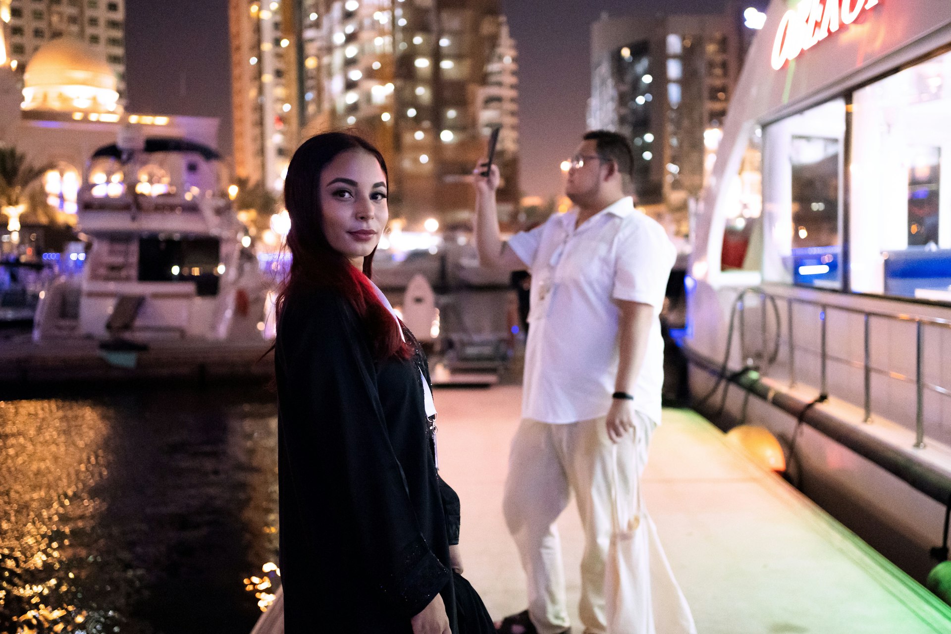 a woman standing next to a man on a dock