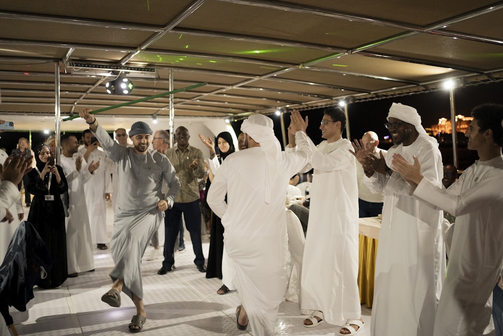 a group of people dressed in white dancing