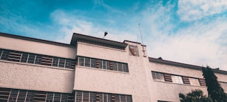 A secure business building with a shield icon overlay, representing commercial insurance protection.