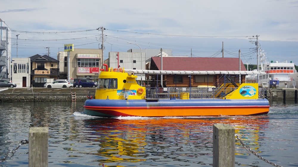 a yellow and blue boat floating on top of a body of water