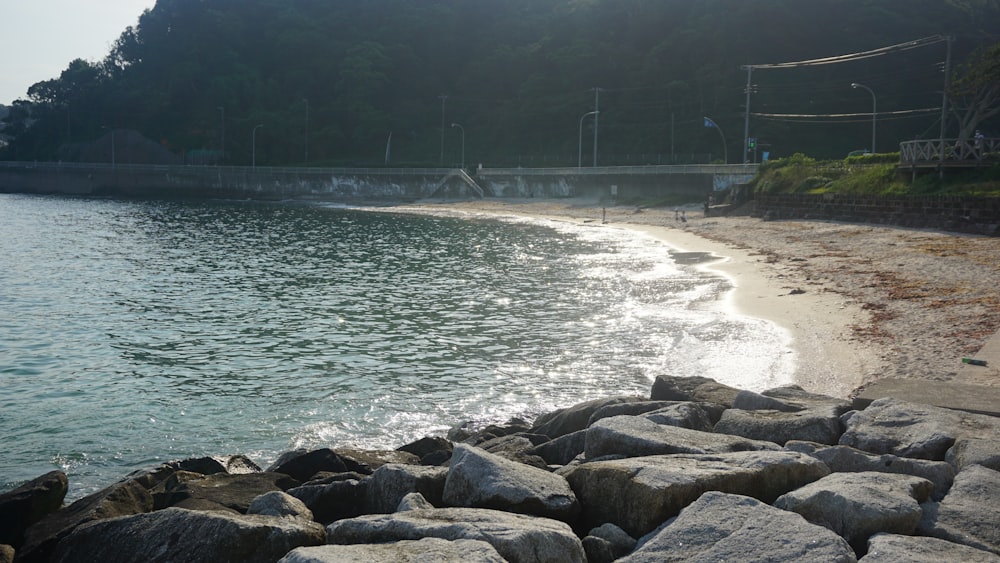 a sandy beach next to a body of water