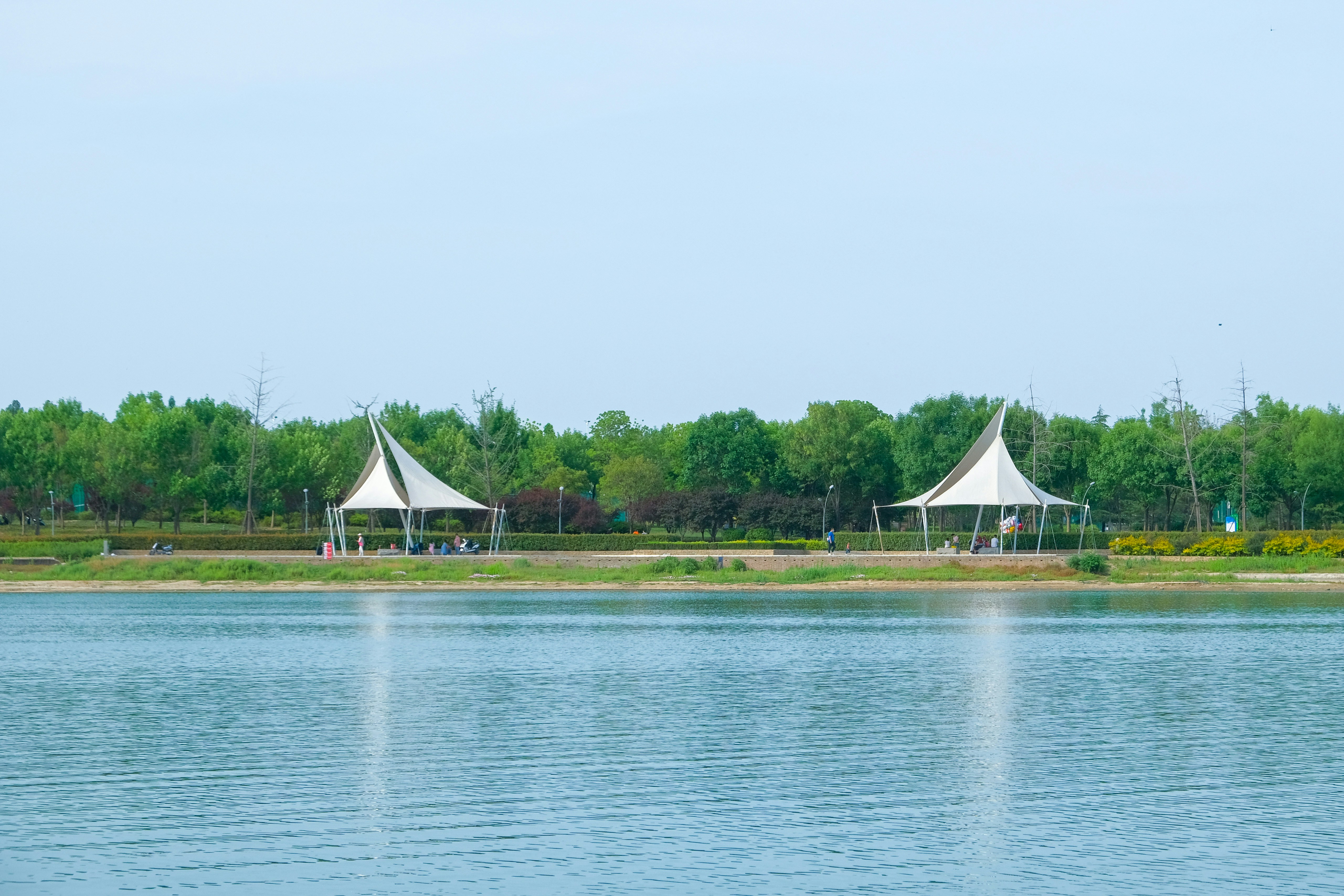 a couple of white tents sitting on top of a lake