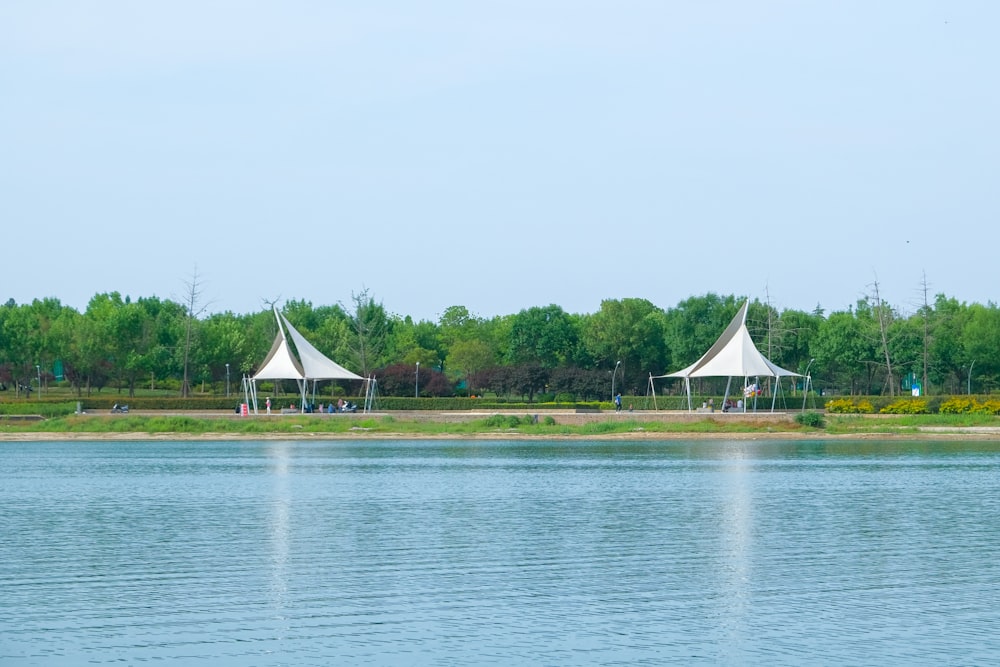 a couple of white tents sitting on top of a lake
