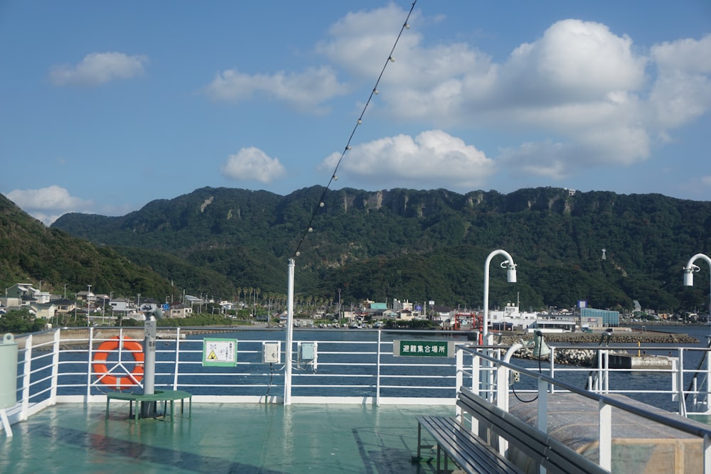 the deck of a cruise ship with mountains in the background