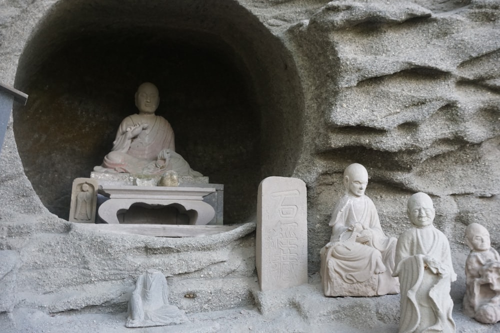 a group of statues sitting in a cave