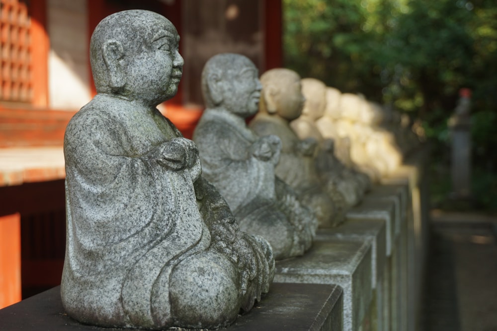 a row of buddha statues sitting next to each other