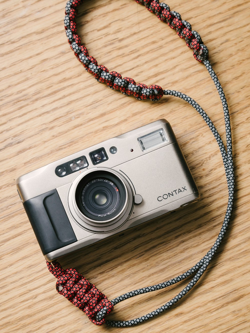 a camera on a wooden table with a rope