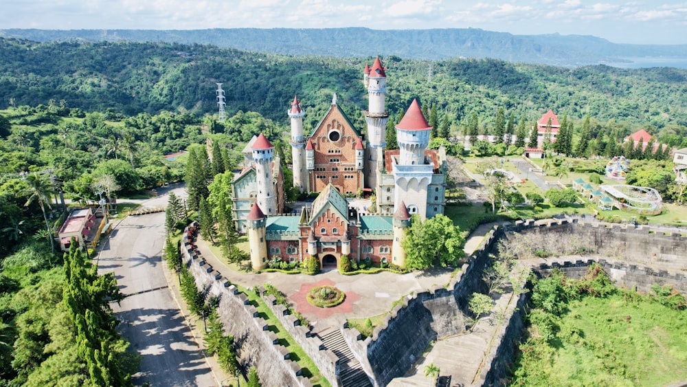 an aerial view of a castle in the middle of a forest