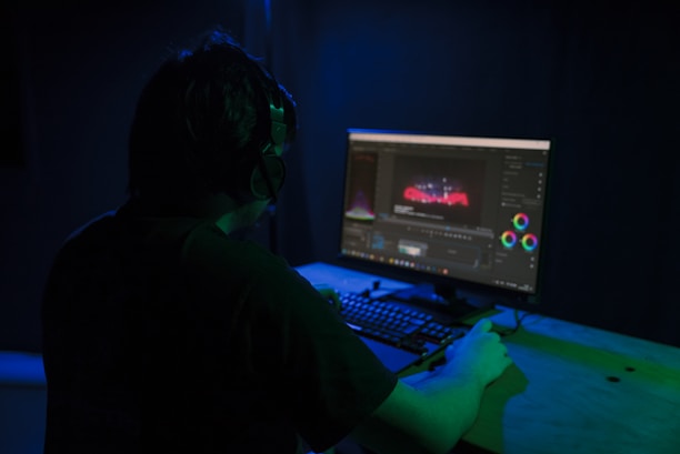 a man sitting in front of a computer in a dark room